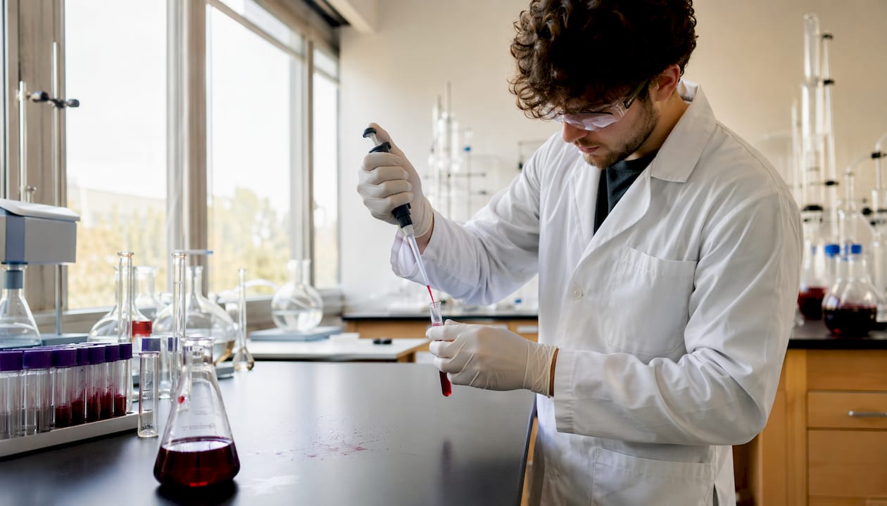 Scientist handling red pigment sample in lab