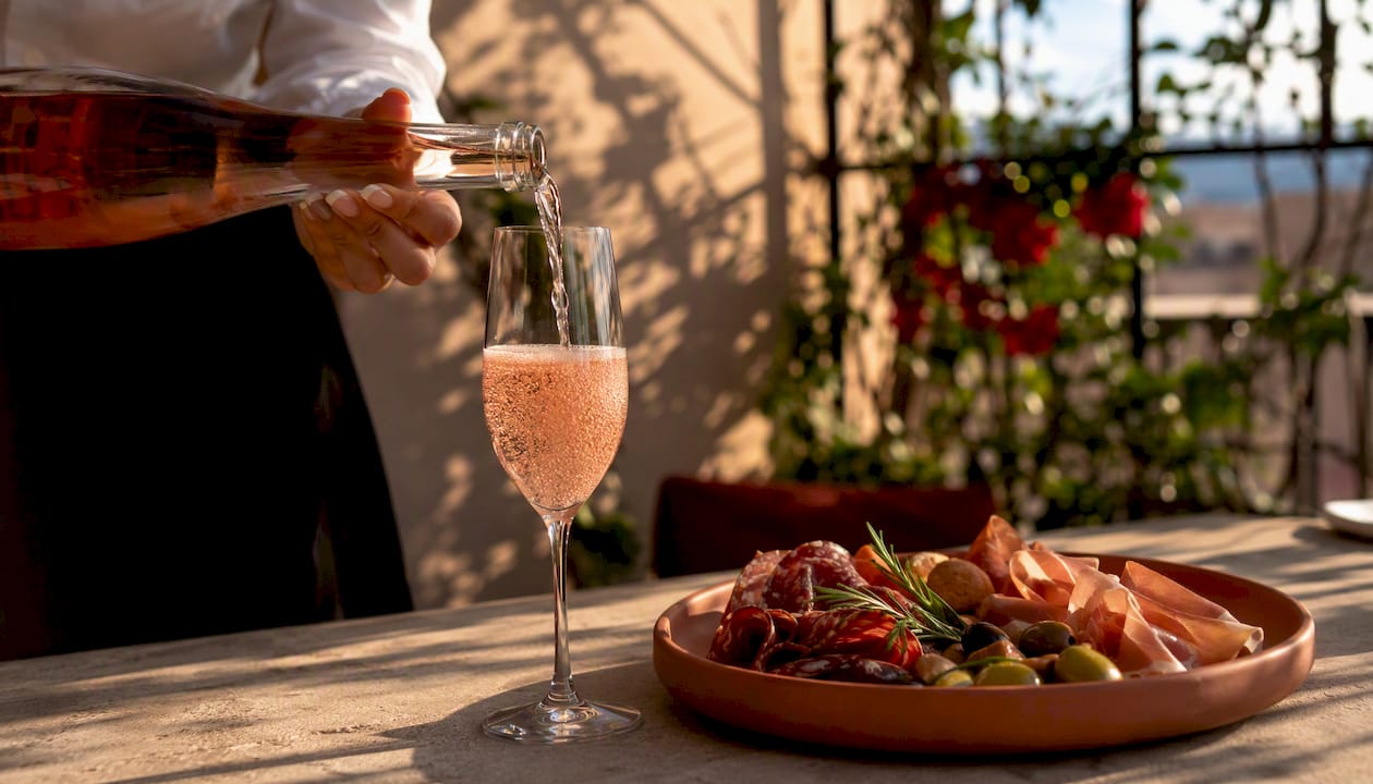 Pouring sparkling wine with canapé on plate
