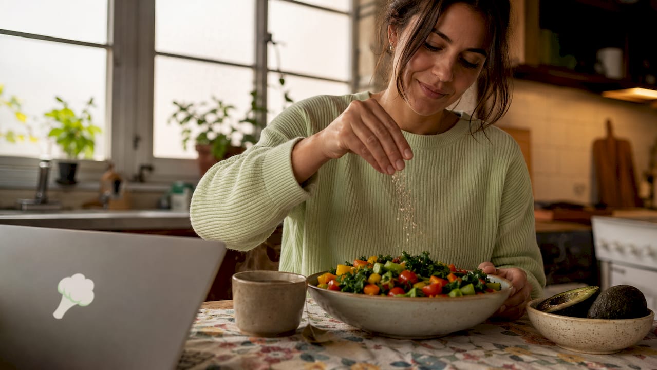 Woman preparing vegetable salad in kitchen