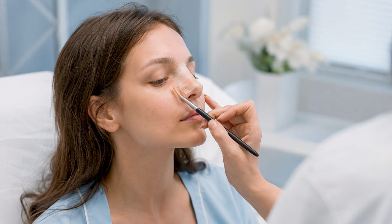 Applying concealer near nose after surgery