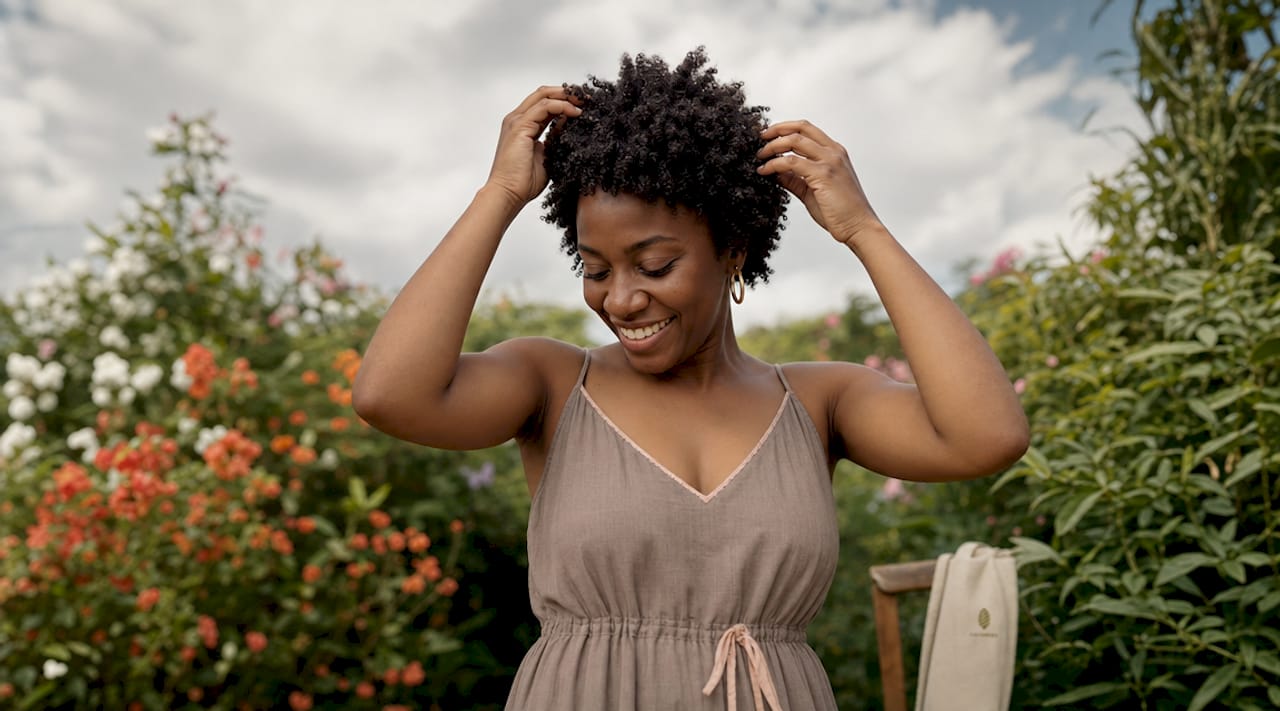 Side profile of woman with tight coily hair outdoors