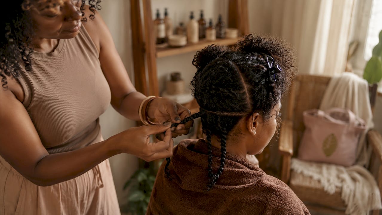 Stylist twisting curly hair into two-strand twists