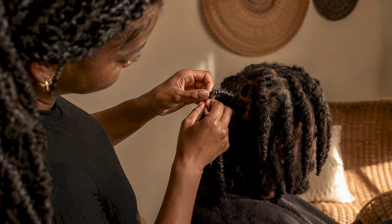 Hands twisting coily locs at roots