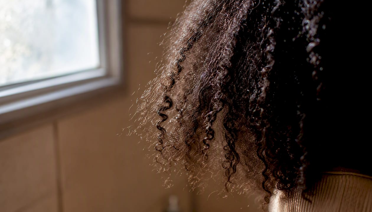 Close-up of curly hair with raised cuticle damage