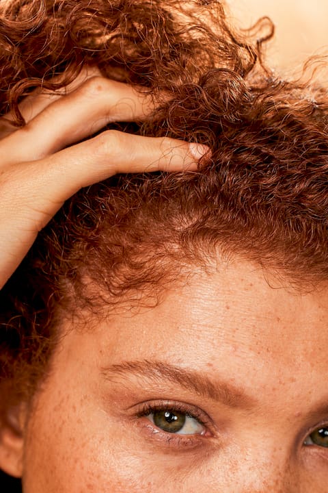 Man detangling curls with fingers and comb