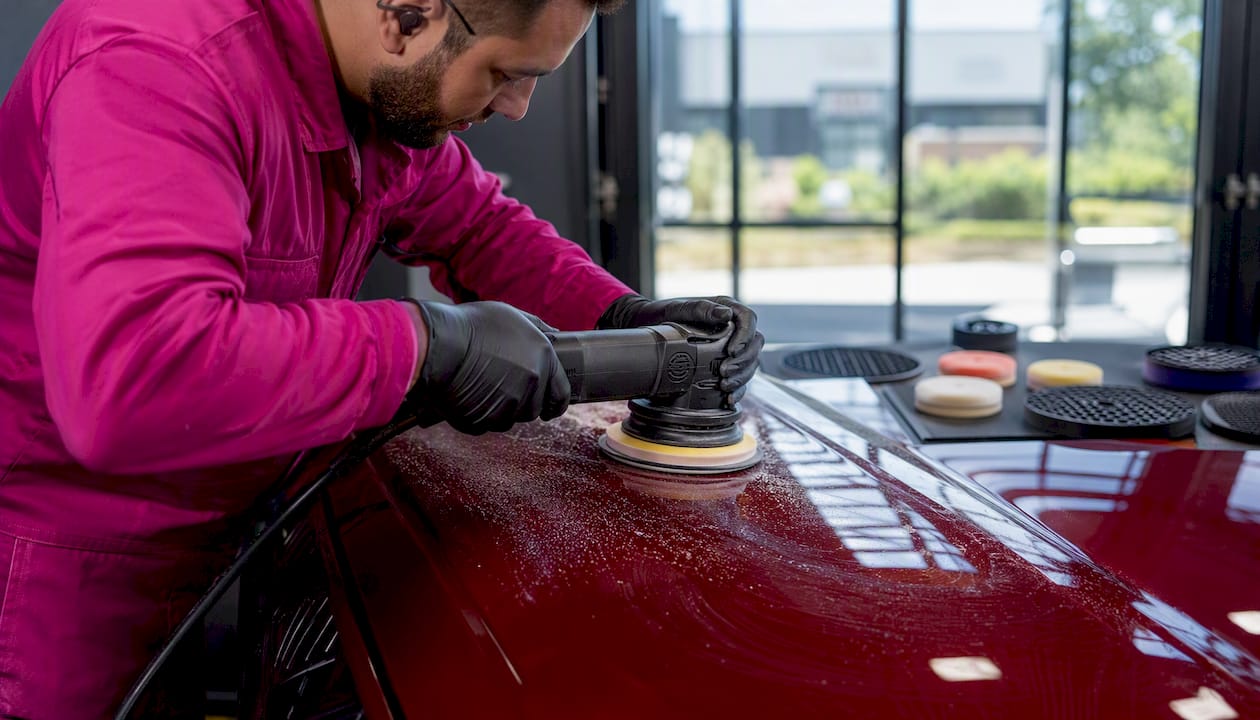 Technician polishing car paint correction