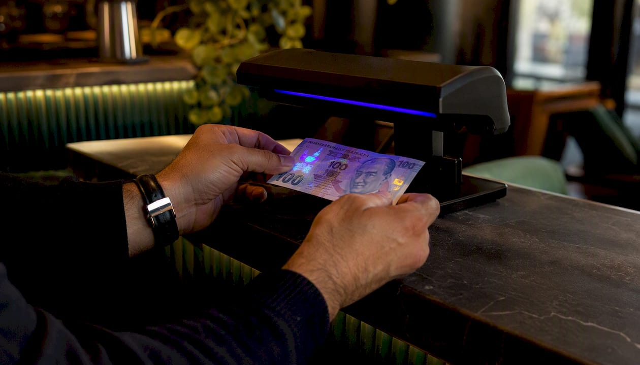 Po specialia UV lempa tikrinami turkiškos liros banknotai