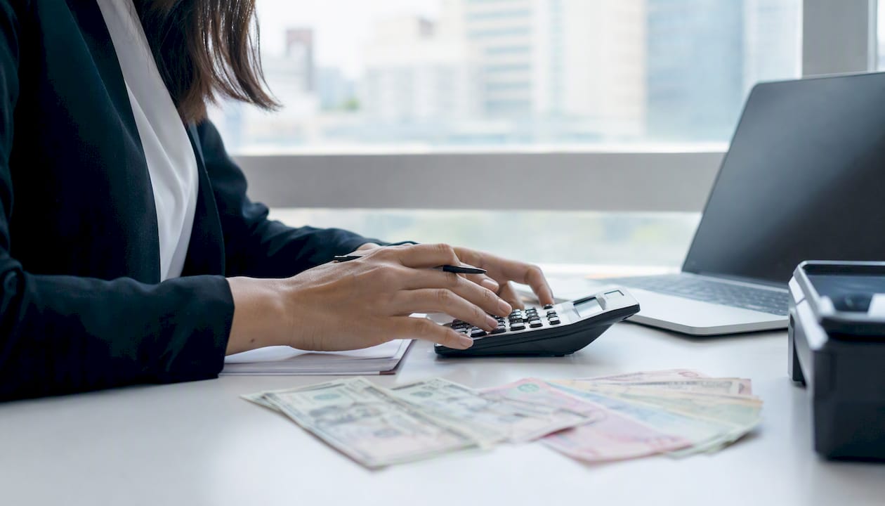 Hands performing foreign receivable currency impact calculation