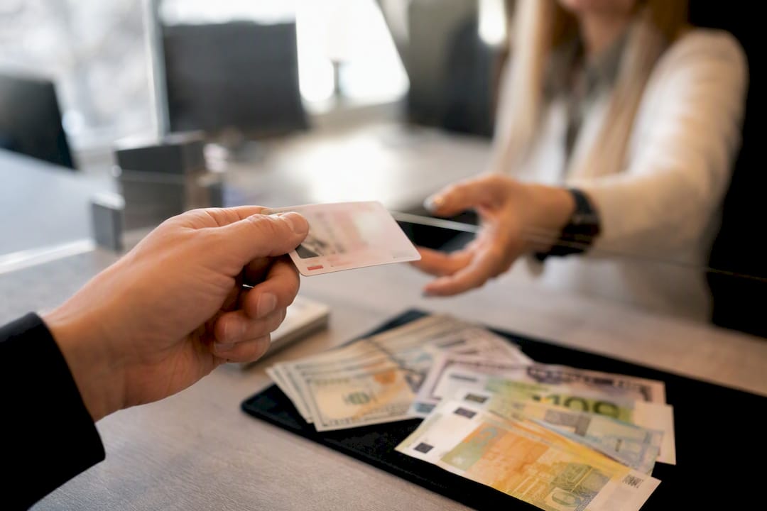 Ranka rodo asmens tapatybės kortelę valiutos keitimo punkte