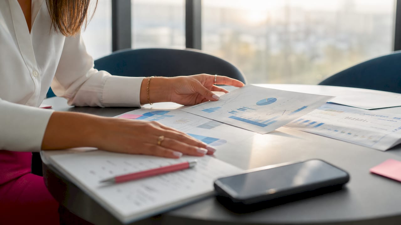 Eine Mitarbeiterin analysiert im Büro die Verkaufszahlen von Immobilien.