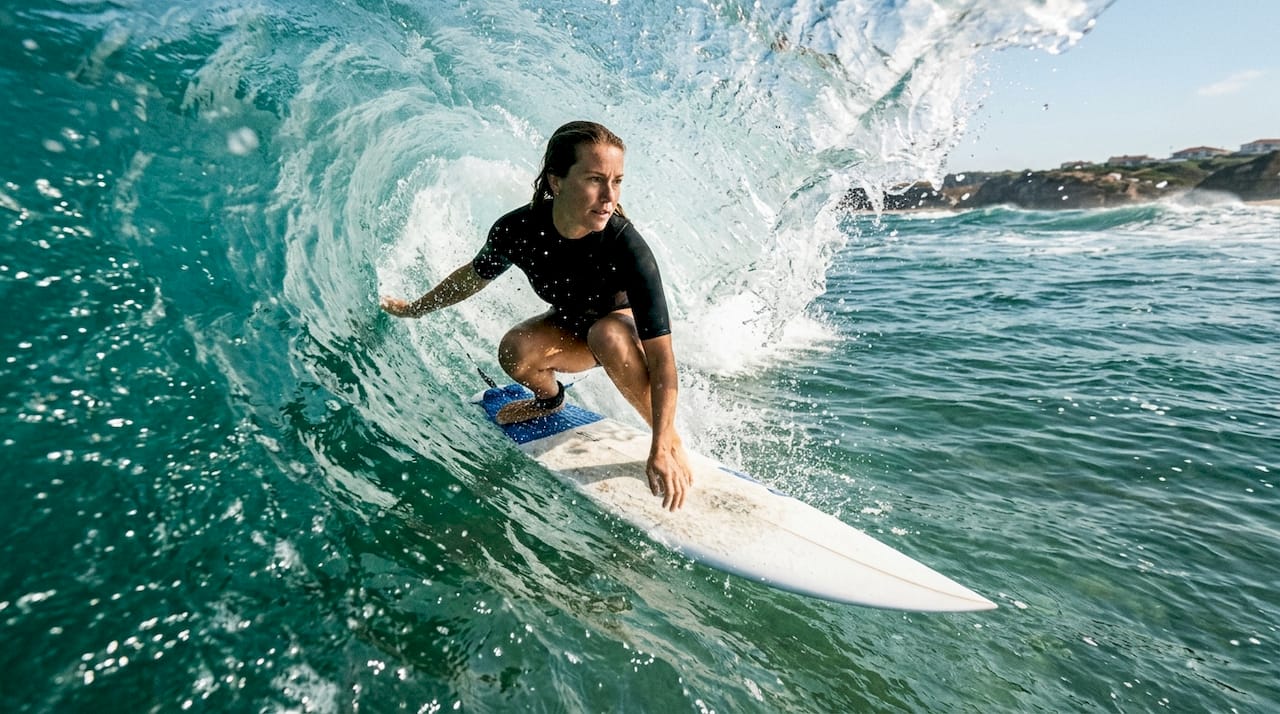 Female surfer riding wave filmed underwater