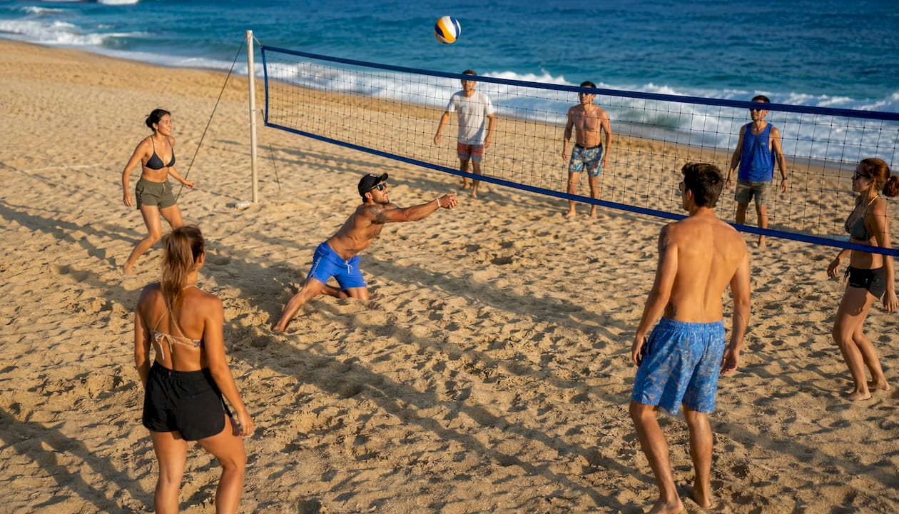 Mixed group playing beach volleyball together