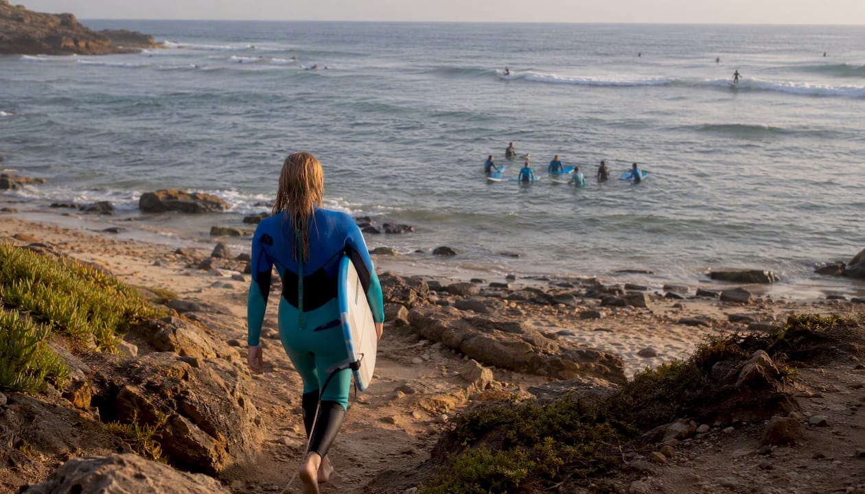 Beginner surfer walking on Portuguese beach