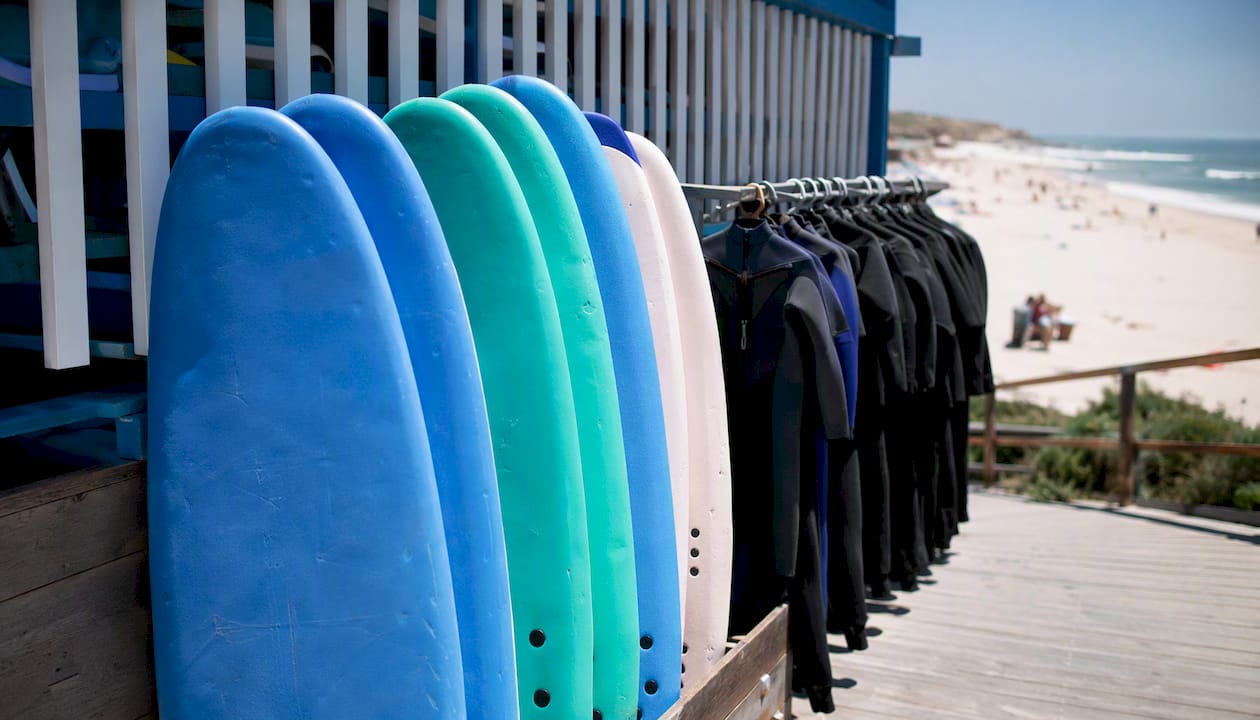 Soft-top surfboards and wetsuits on rack