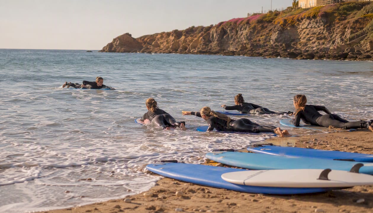 Women group paddle coaching at Portuguese beach