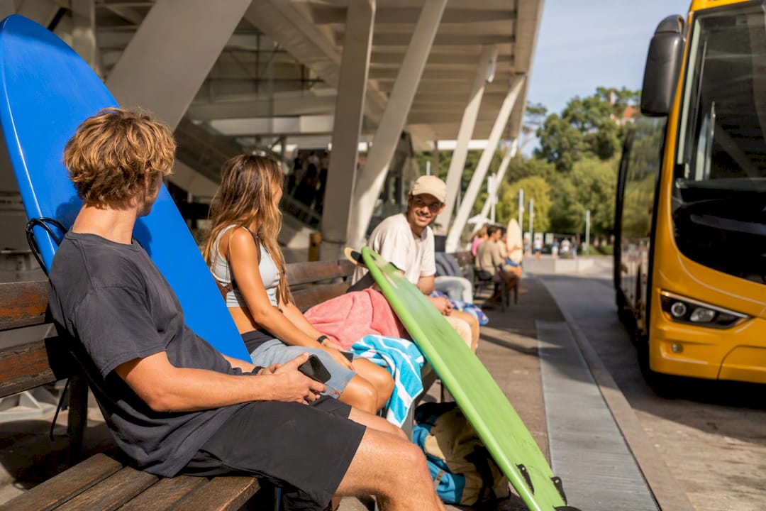 Busy Lisbon bus terminal with travelers and bus