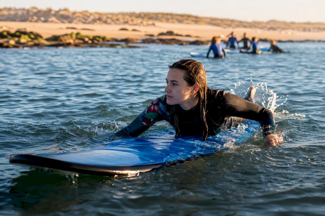 Surfer paddling during lesson in Portuguese ocean