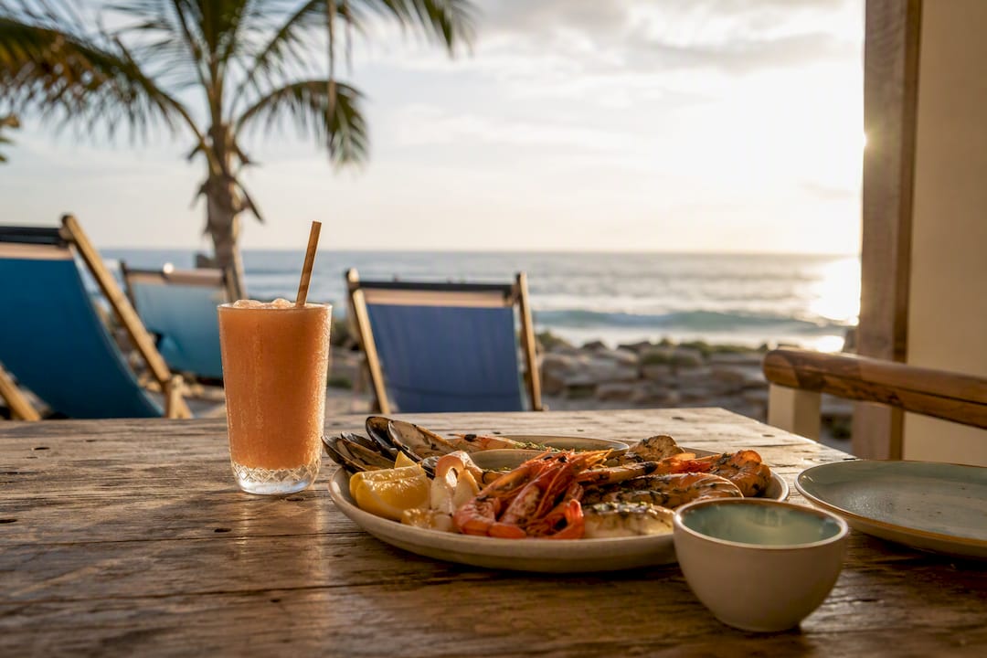 Neapolitan pizza and cheeseburger on beach bar table