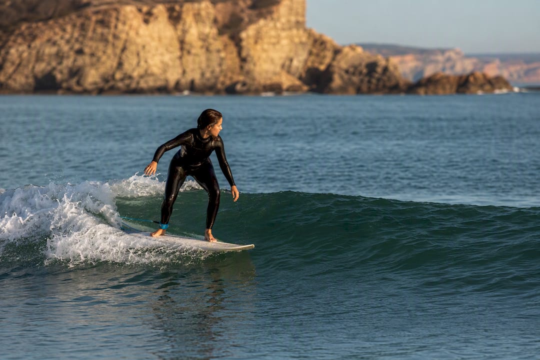 Beginner surfer riding a small green wave