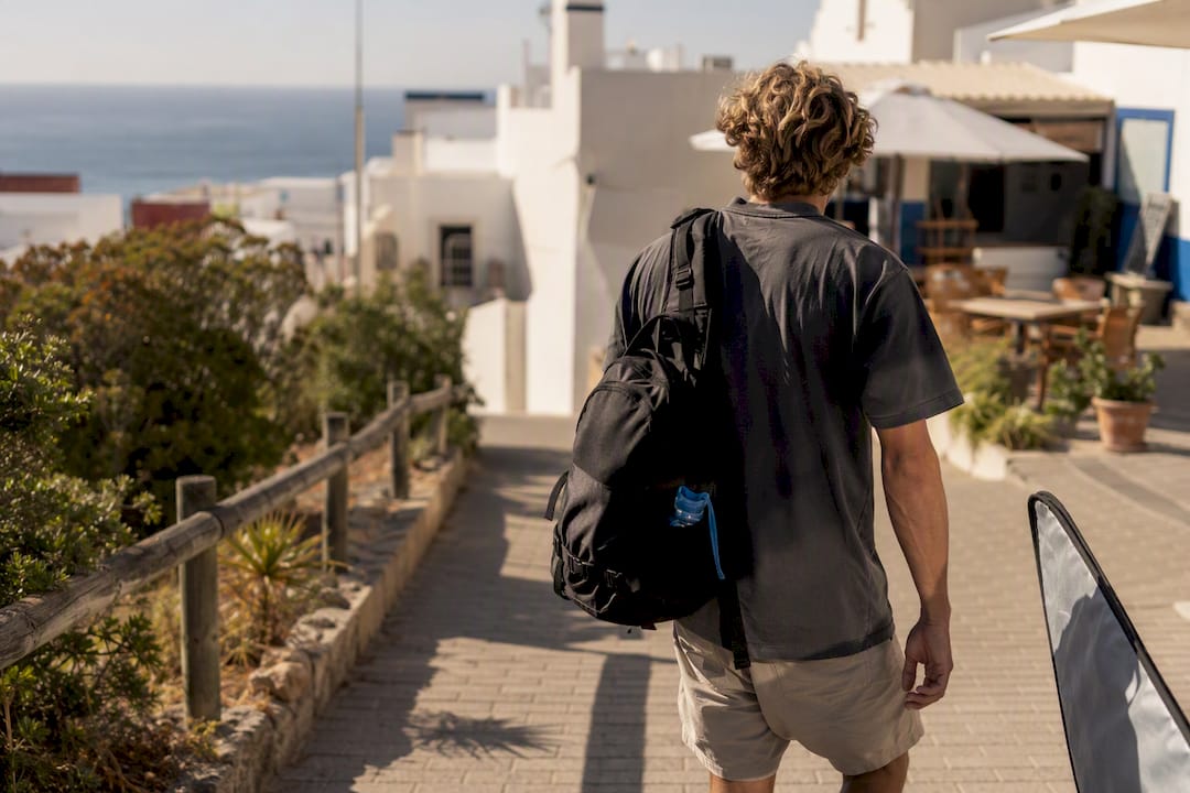 Traveler walking toward coastal surf village