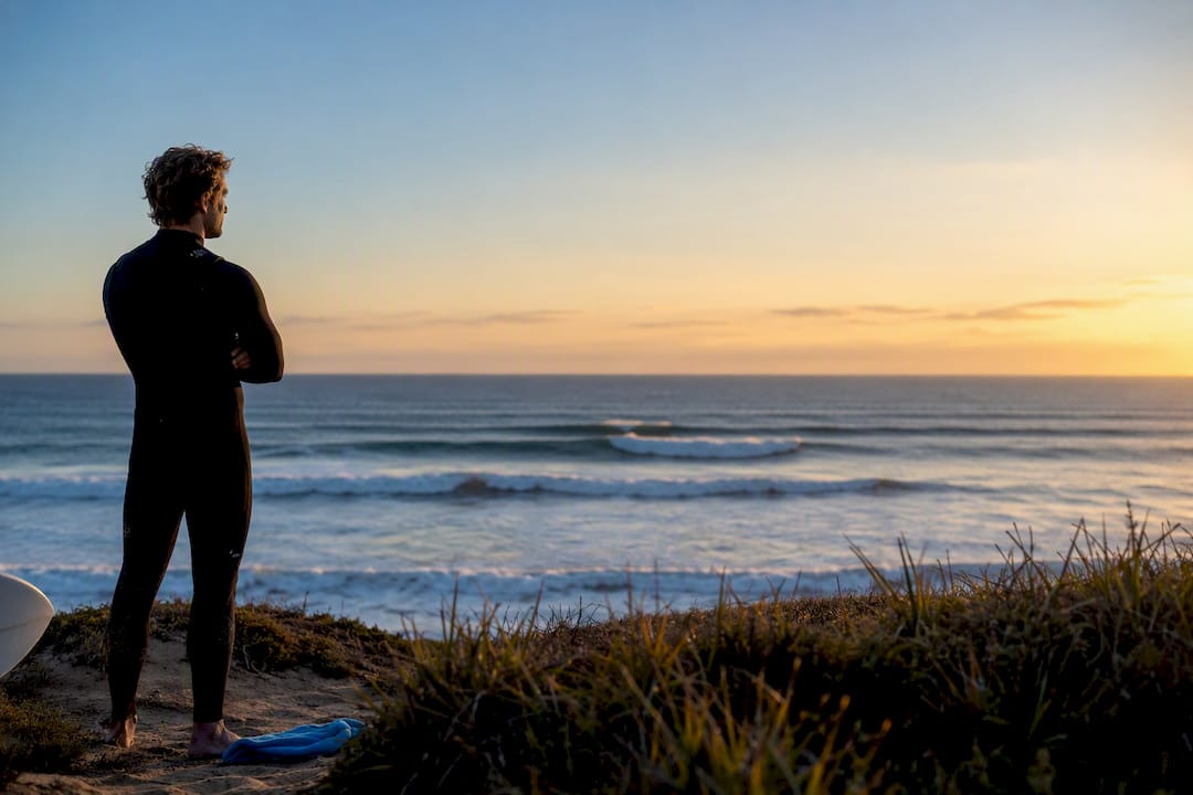 Surfer reading Ericeira waves at sunrise
