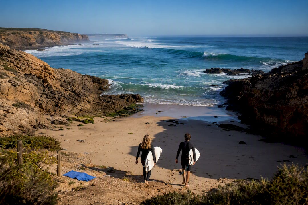 Surfers entering a sheltered Portuguese cove