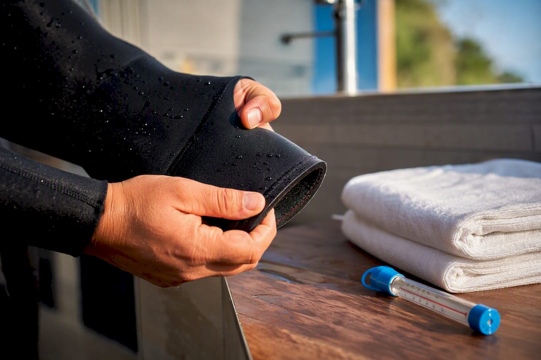 Hands checking thick neoprene wetsuit material