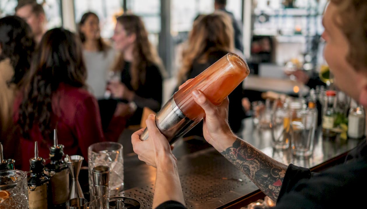 Bartender's hands pouring cocktail at local bar