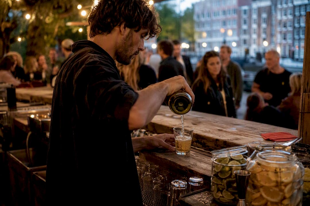 Bartender pouring draft beer at bar