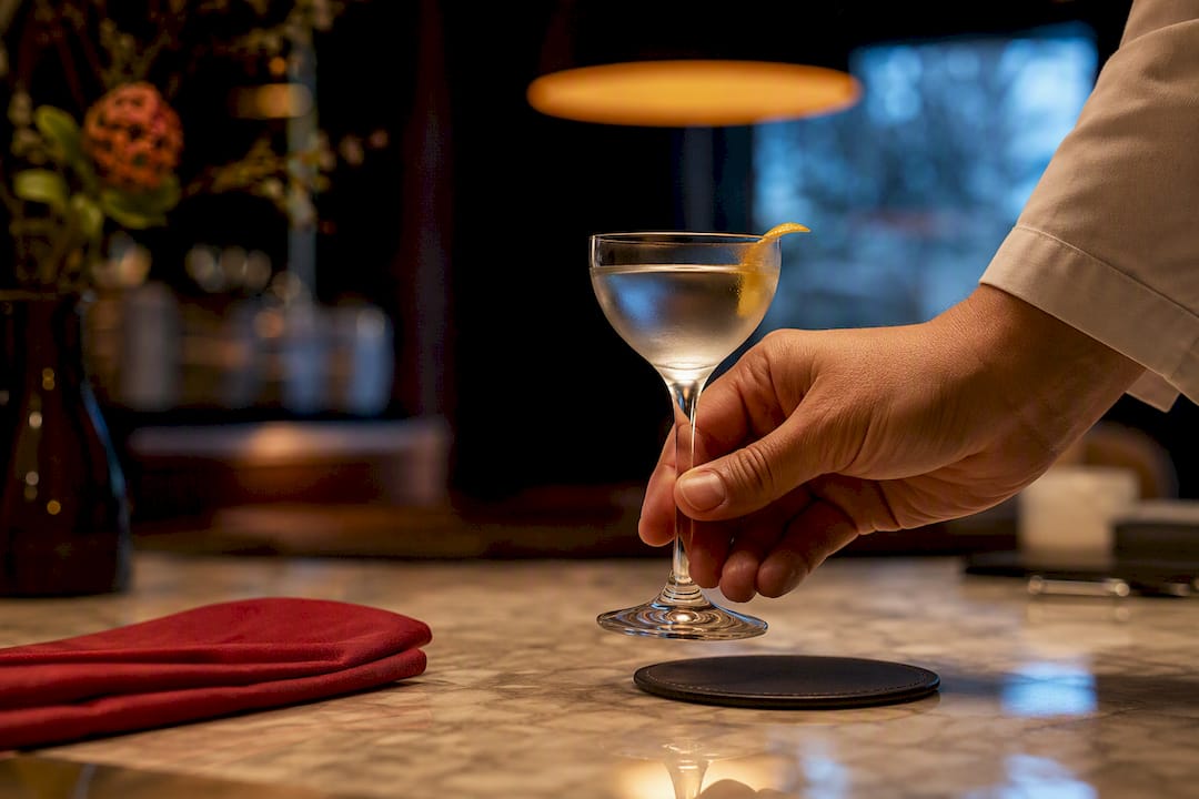 Hand holding stemmed cocktail glass