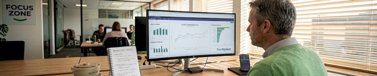 Een data-analist bekijkt het feedbackdashboard op kantoor.
