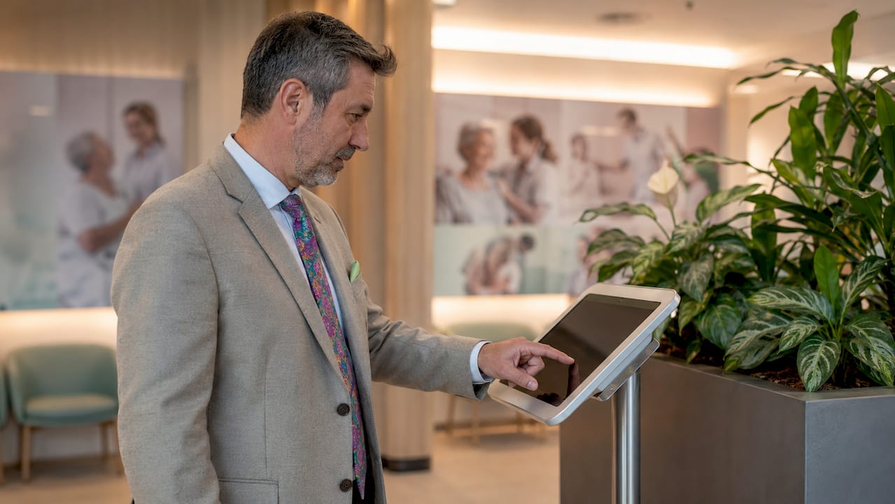 Man vult feedback in op een touchscreen in de wachtruimte