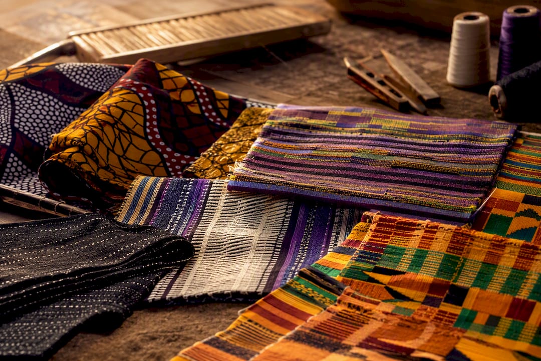 Assorted West African fabrics and weaving tools overhead