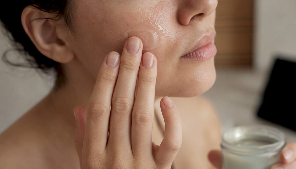 Hands applying gel moisturizer on face