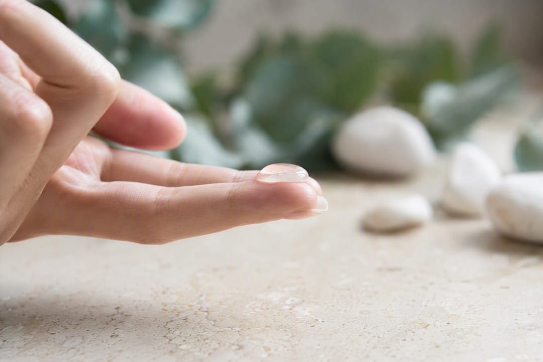Clear gel serum droplet on fingertip