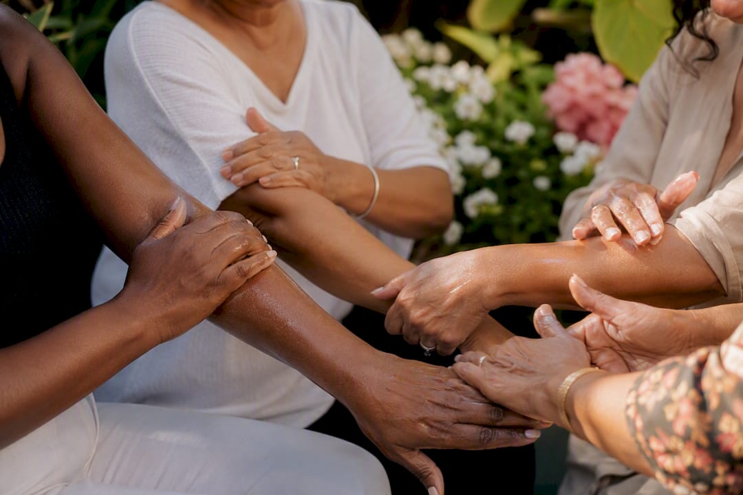 Diverse mature women applying skincare on hands