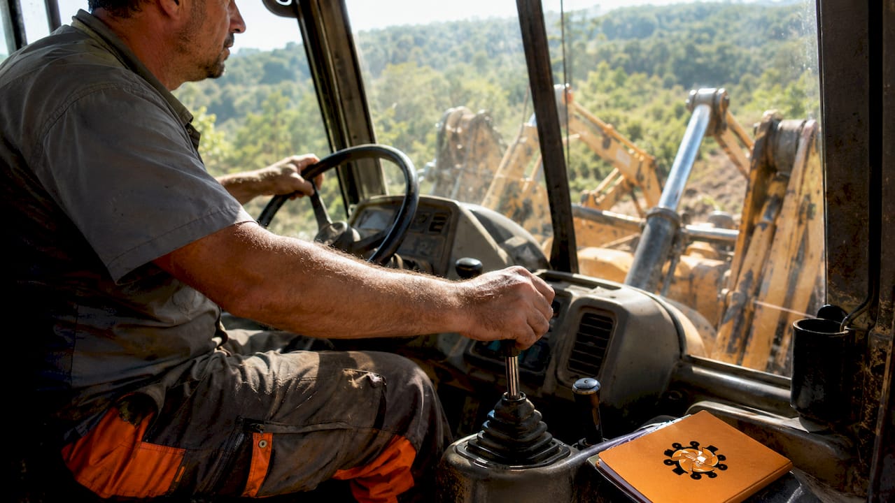 Mâinile operatorului pe maneta de viteze a unui Volvo BL71