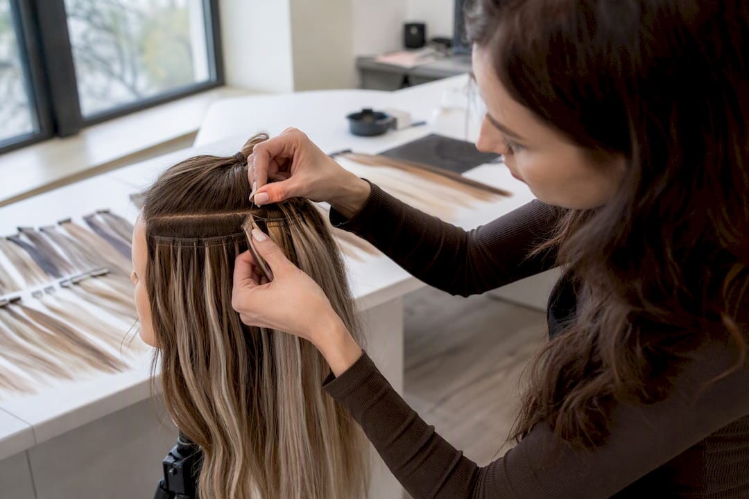 Ręce rozkładają nierównomiernie pasemka balayage