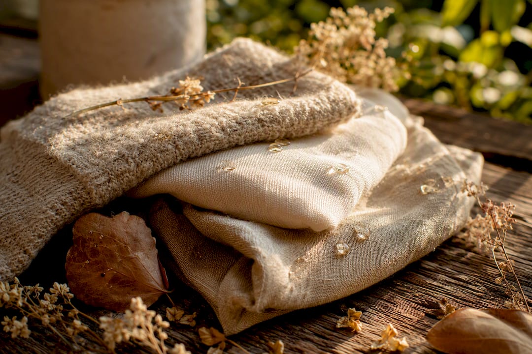 Close-up of wool, cotton, and linen fibers with fragrance droplets