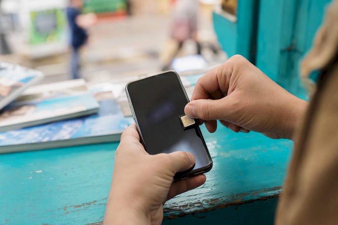 Hands inserting SIM card into phone