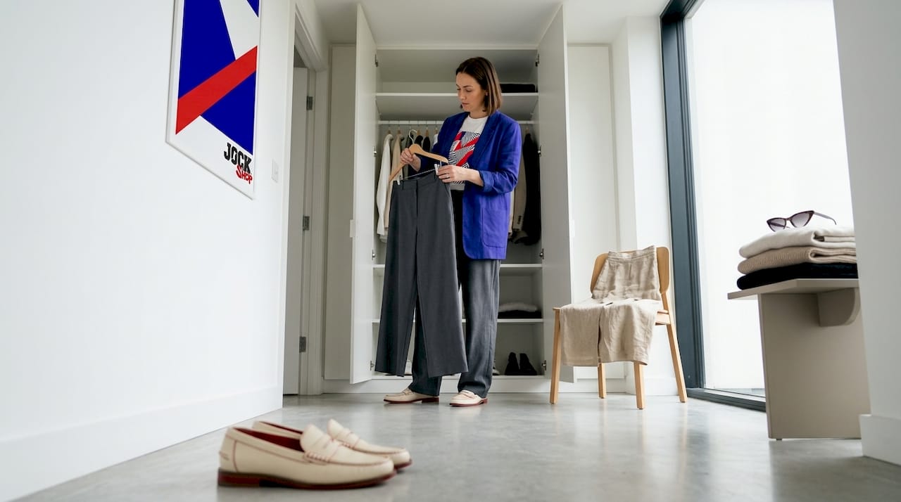 Woman curates relaxed tailored wardrobe at home