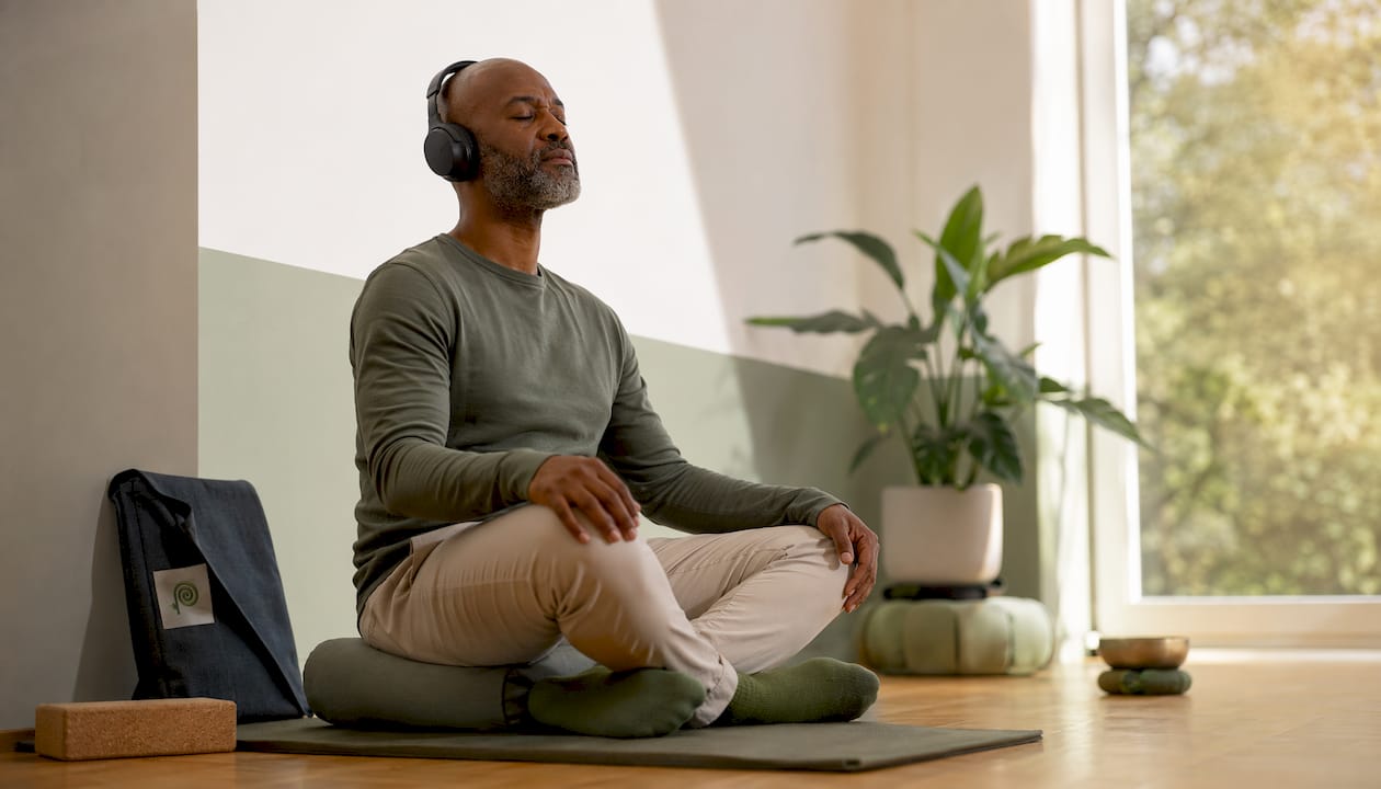 Un uomo si rilassa ascoltando una meditazione guidata con le cuffie
