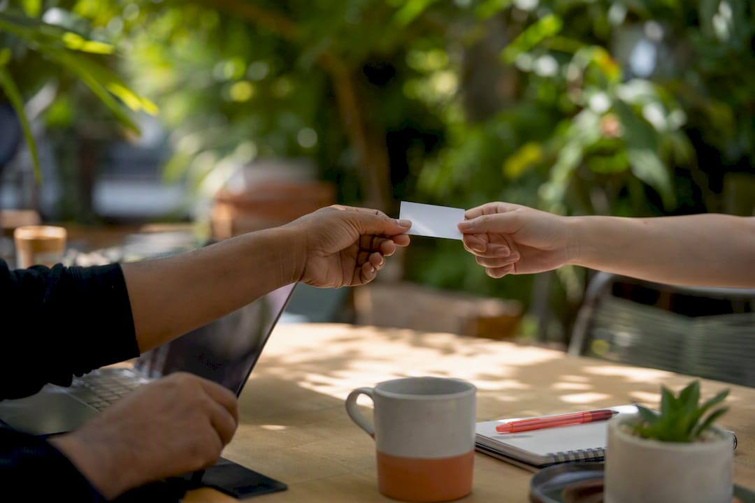 Hands exchanging referral card