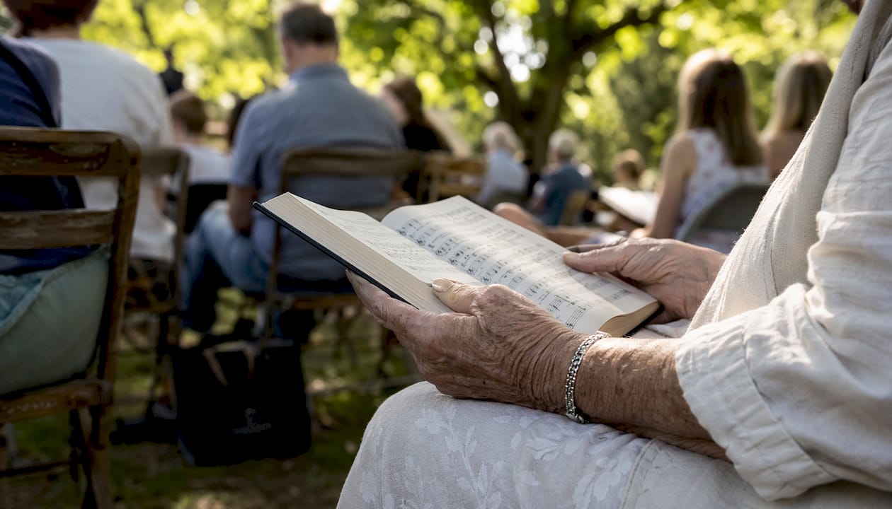 Hands holding open hymnal in church