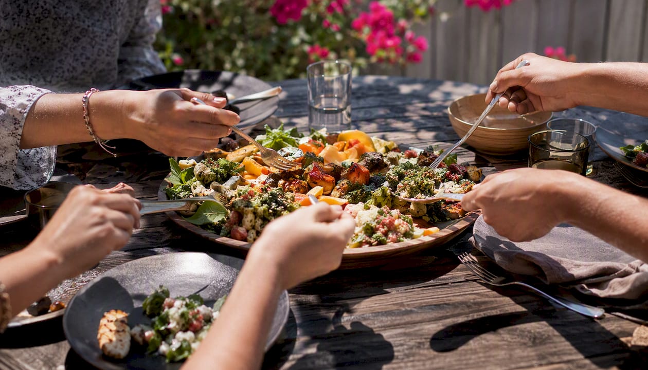 Hands sharing food at dining table