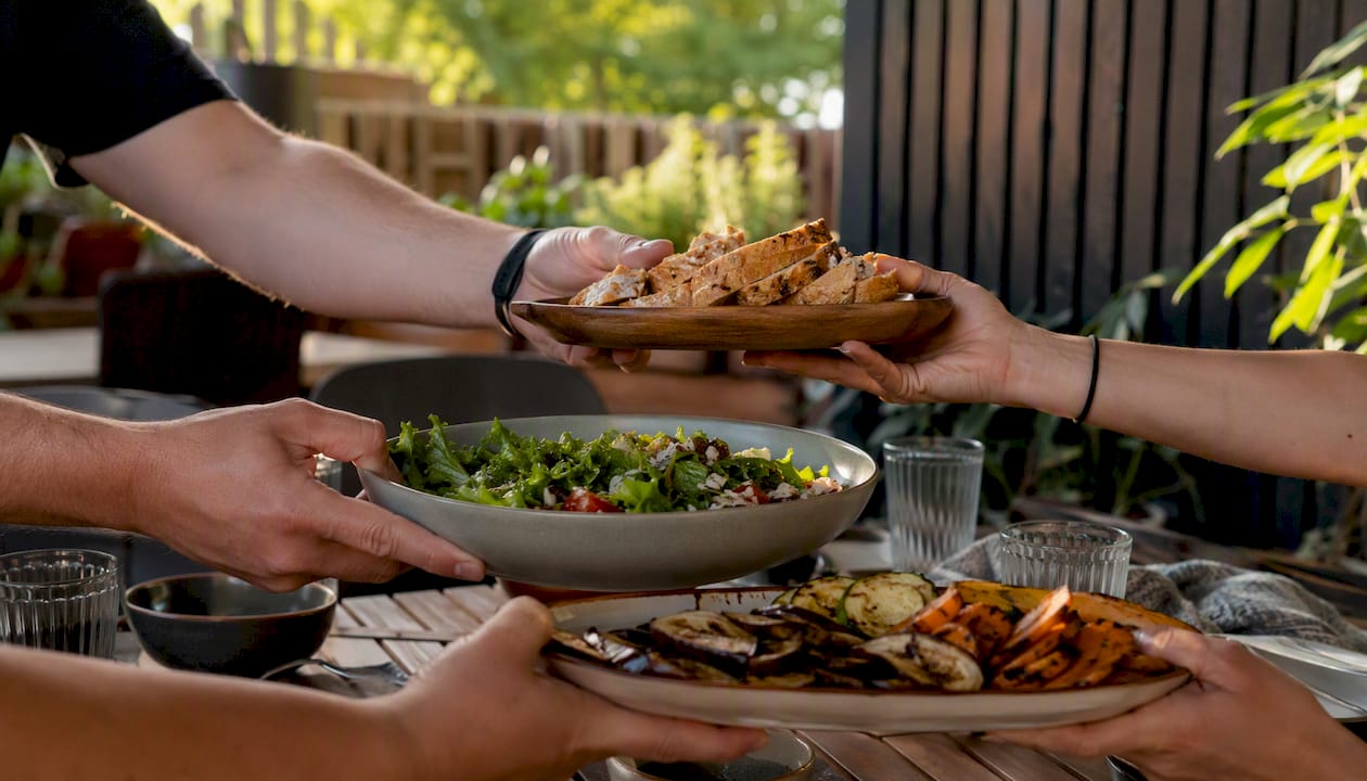 Hands sharing food at a small community meal