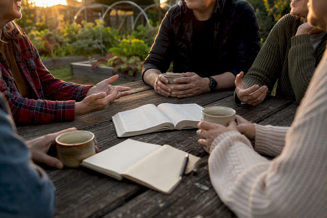 Hands and arms in small group conversation outdoors