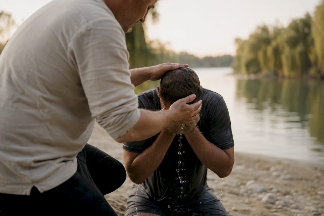 Water poured over hands outdoors at baptism