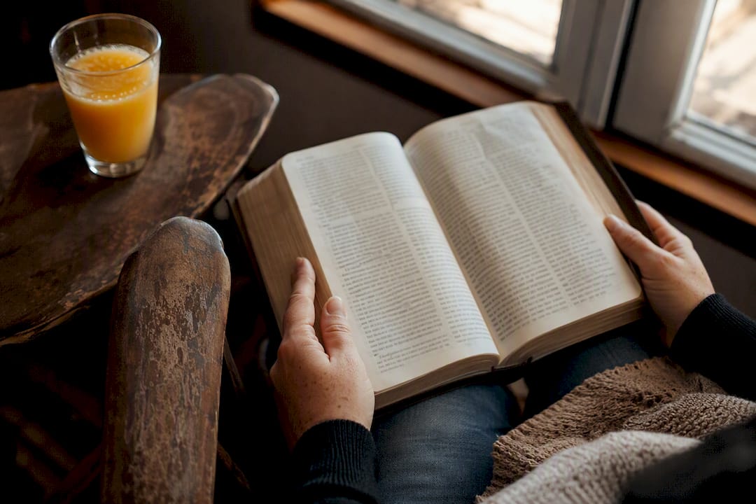 Hands holding open Bible for lectio divina