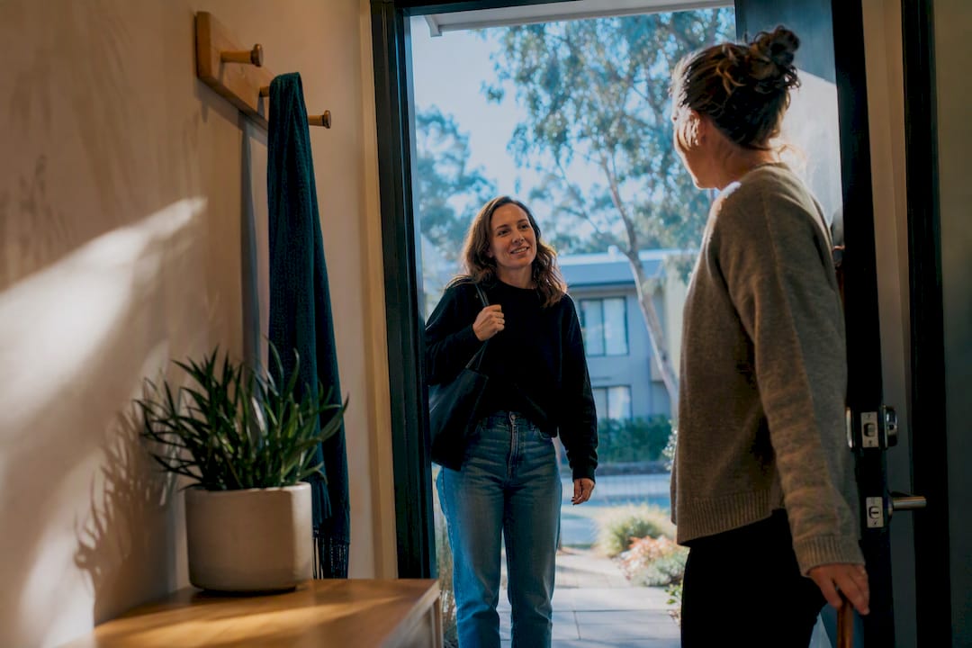 Friend offering support at a doorway